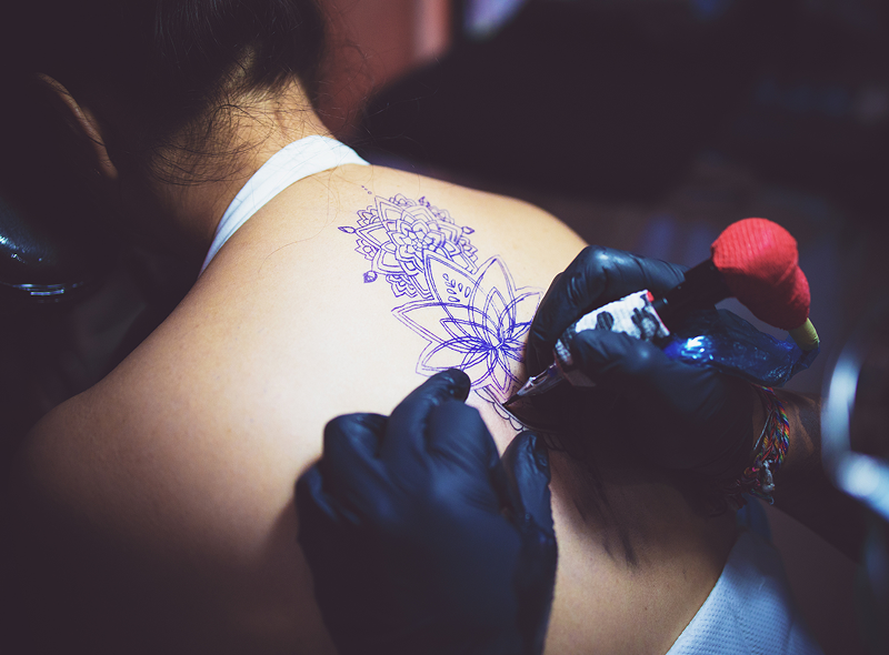 Tattoo artist inking floral design