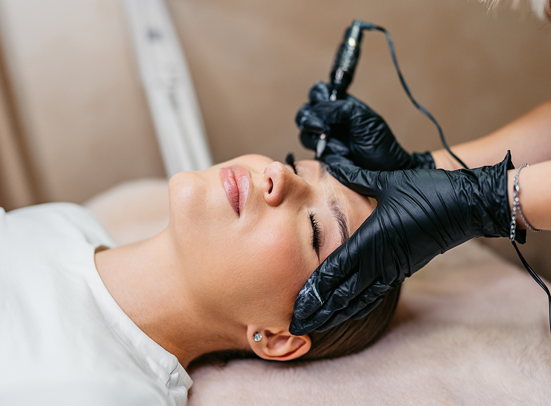 Woman receiving eyebrow microblading treatment